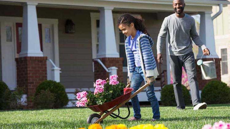 Father and daughter doing spring yard cleaning.